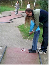 Vader leert dochter midgetgolfen